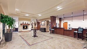 A spacious lobby with a fireplace, a reception desk, and a bar area. - Comfy Studio Suite | Free Breakfast + Outdoor Pool (San Antonio)