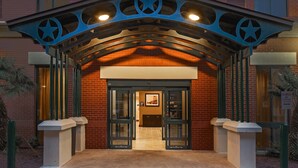 A hotel entrance with a star-shaped roof and glass doors. - Comfy Studio Suite | Free Breakfast + Outdoor Pool (San Antonio)
