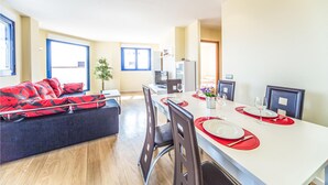 Un appartement moderne comprenant un coin repas, un salon avec un canapé et une cuisine.
