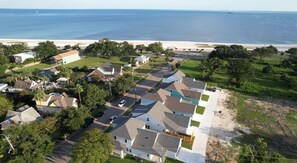Ett bostadsområde med hus, en strand och en fri utsikt över havet.