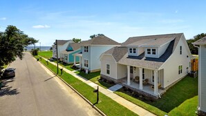 A row of single-family homes with a paved driveway and a grassy lawn.