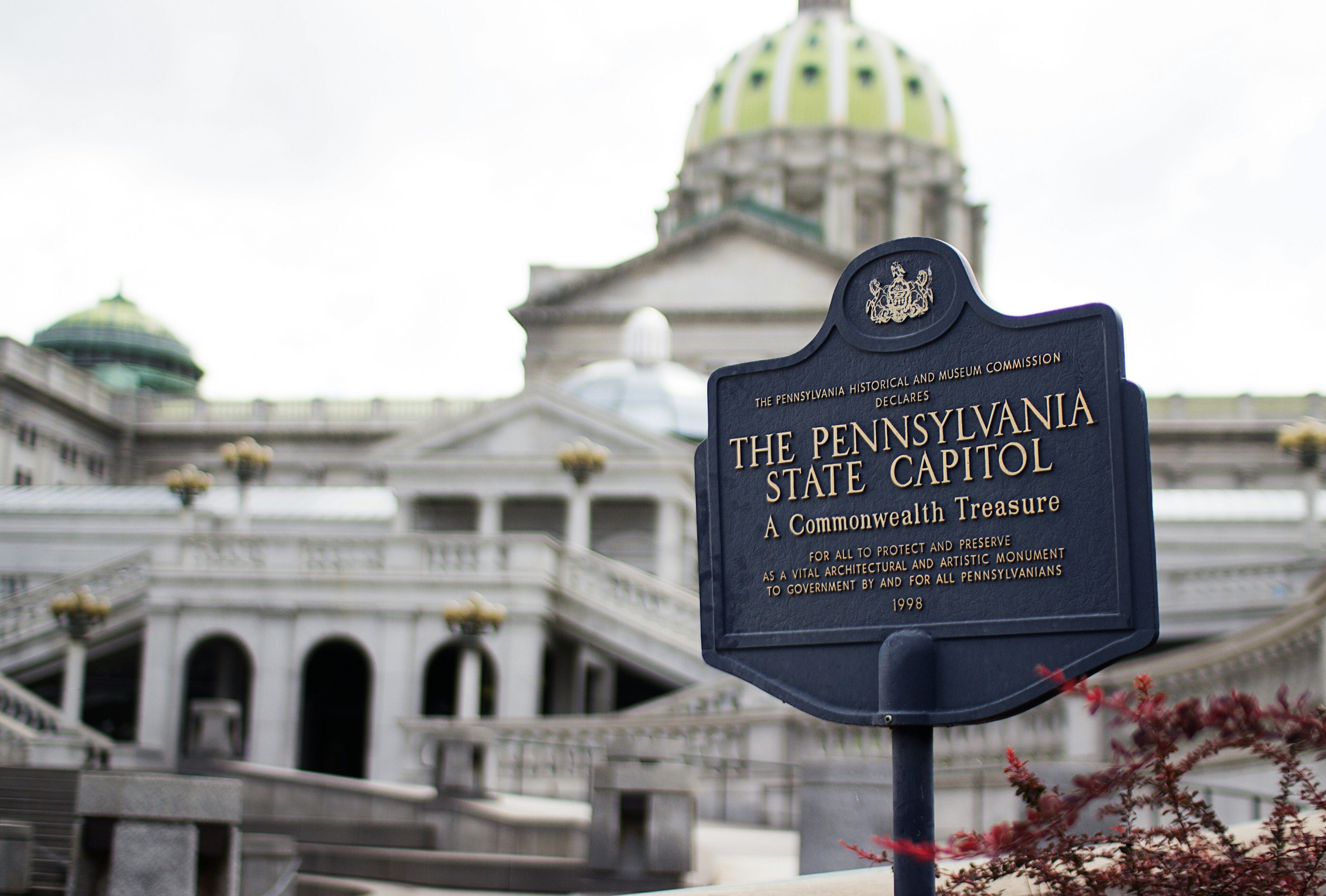 A sign in front of the Pennsylvania State Capitol building.