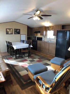 Cozy living space with a kitchenette and dining area, featuring a table for four and comfortable seating.
