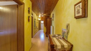 A hallway with wooden ceiling and yellow walls, featuring a wooden table with a lace tablecloth and a framed picture on the wall. - Amazing apartment in Racines/Ratschings (Racines/Ratschings)