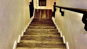 Eine Holztreppe mit weißen Geländern und einer Aussichtsplattform mit einer Tür.