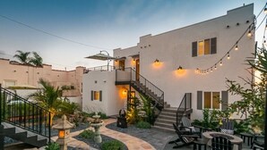 Un edificio moderno con patio, arredo esterno, una scalinata e luci a stringa.