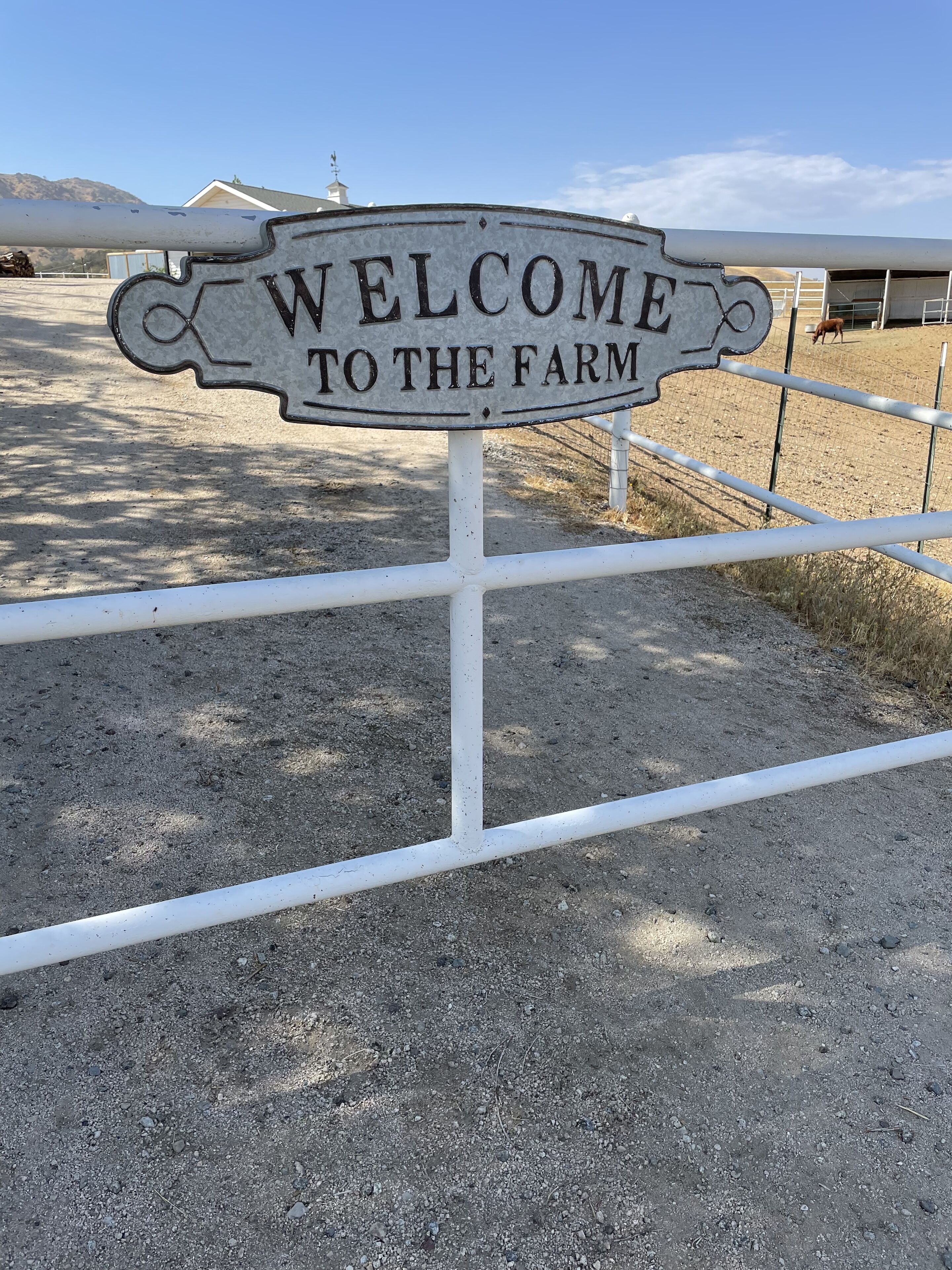 A welcome sign at a farm entrance.