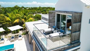 Un moderno resort con piscina, mobiliario exterior y vista al océano.