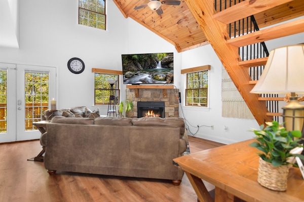 Sit at the table with your coffee and still be part of the conversation by the fire — the whole main floor reads as one room.