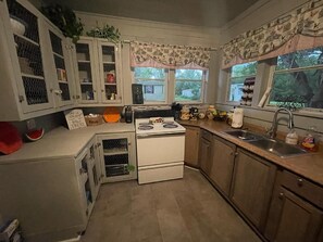 Une cuisine de taille réduite, équipée d’une cuisinière, d’un évier et de placards.
