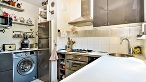 A compact kitchen with a washing machine, a gas stove, and a sink. - 2 bedroom gorgeous apartment in Orange (Orange)