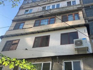 Ein mehrstöckiges Gebäude mit mehreren Fenstern und einer Klimaanlage an der Außenwand.