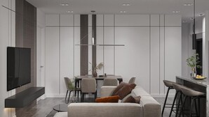 Een moderne woonkamer met een bank, een eettafel en een aan de muur bevestigde televisie.