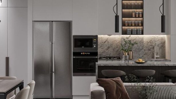 Een moderne keuken met een ingebouwde oven, een koelkast en een eethoek met een tafel en stoelen.