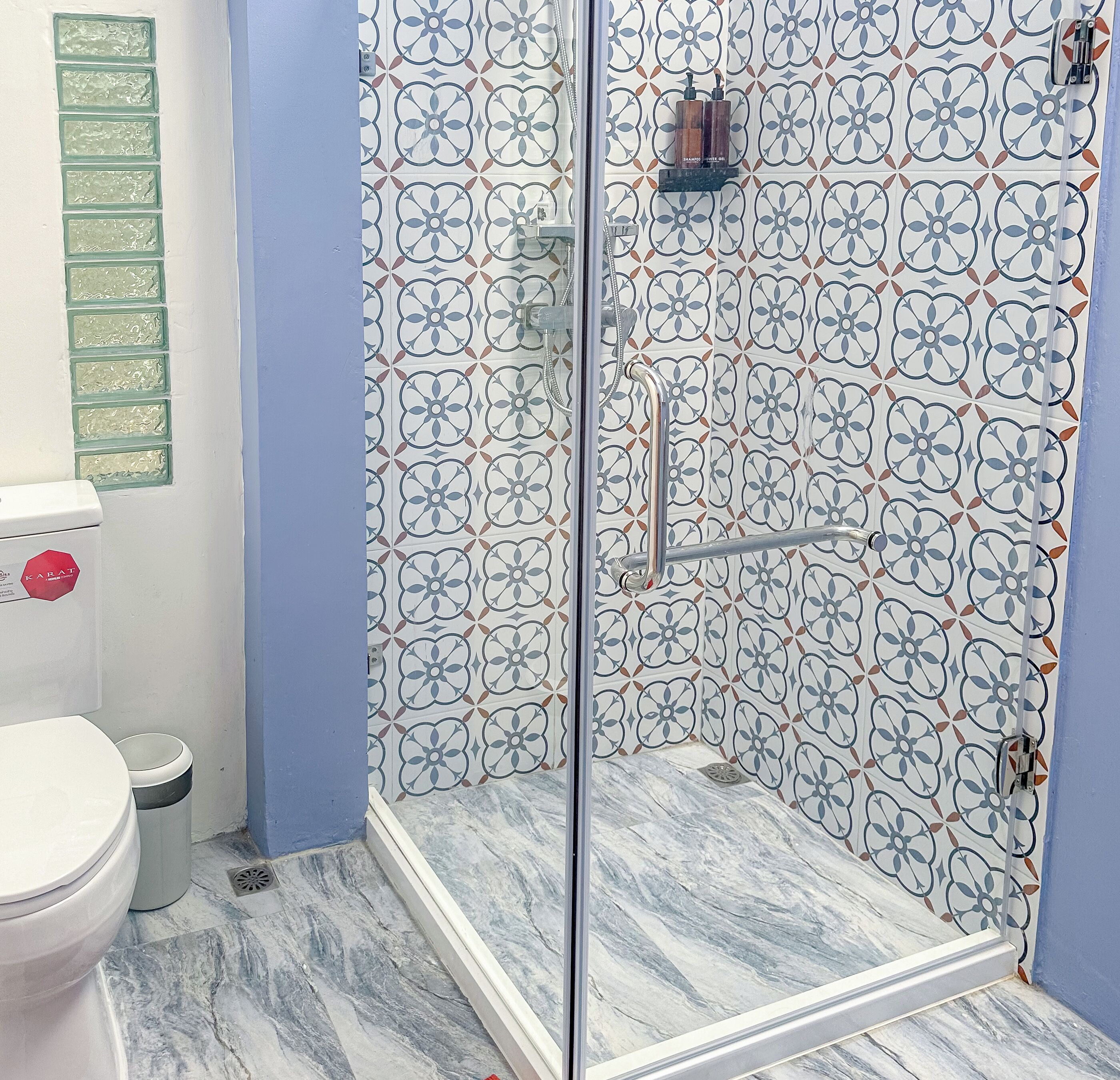 A bathroom with a shower, toilet, and sink.