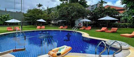 Una piscina al aire libre, sillones reclinables de piscina