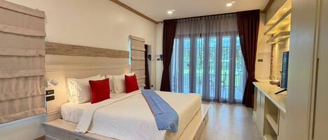 A hotel room with a large bed, bedside tables, a TV, and a view of the outdoors.