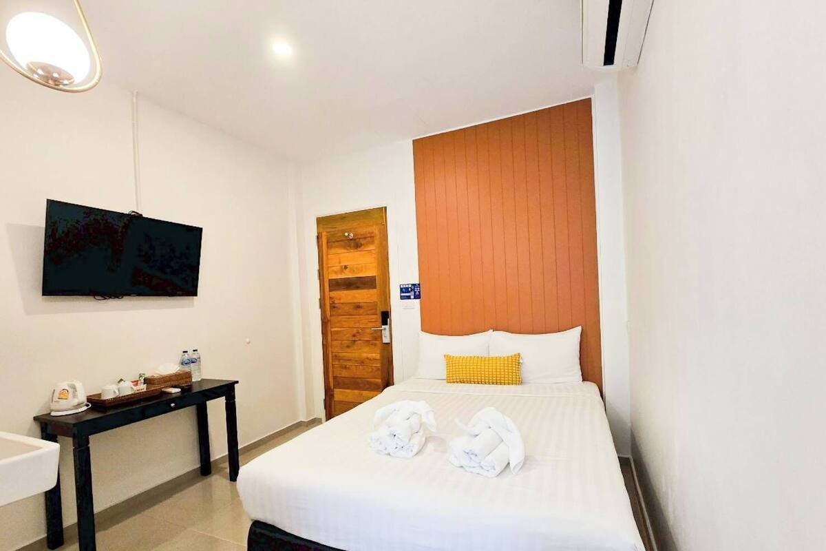 Une chambre d’hôtel avec un lit, une télévision, un bureau et une salle de bain.