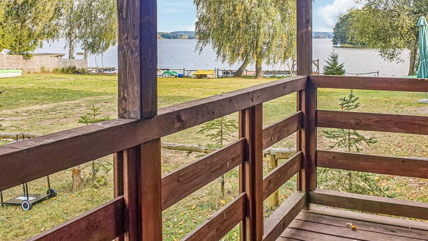 Eine Holzterrasse mit Blick auf einen See und Boote.