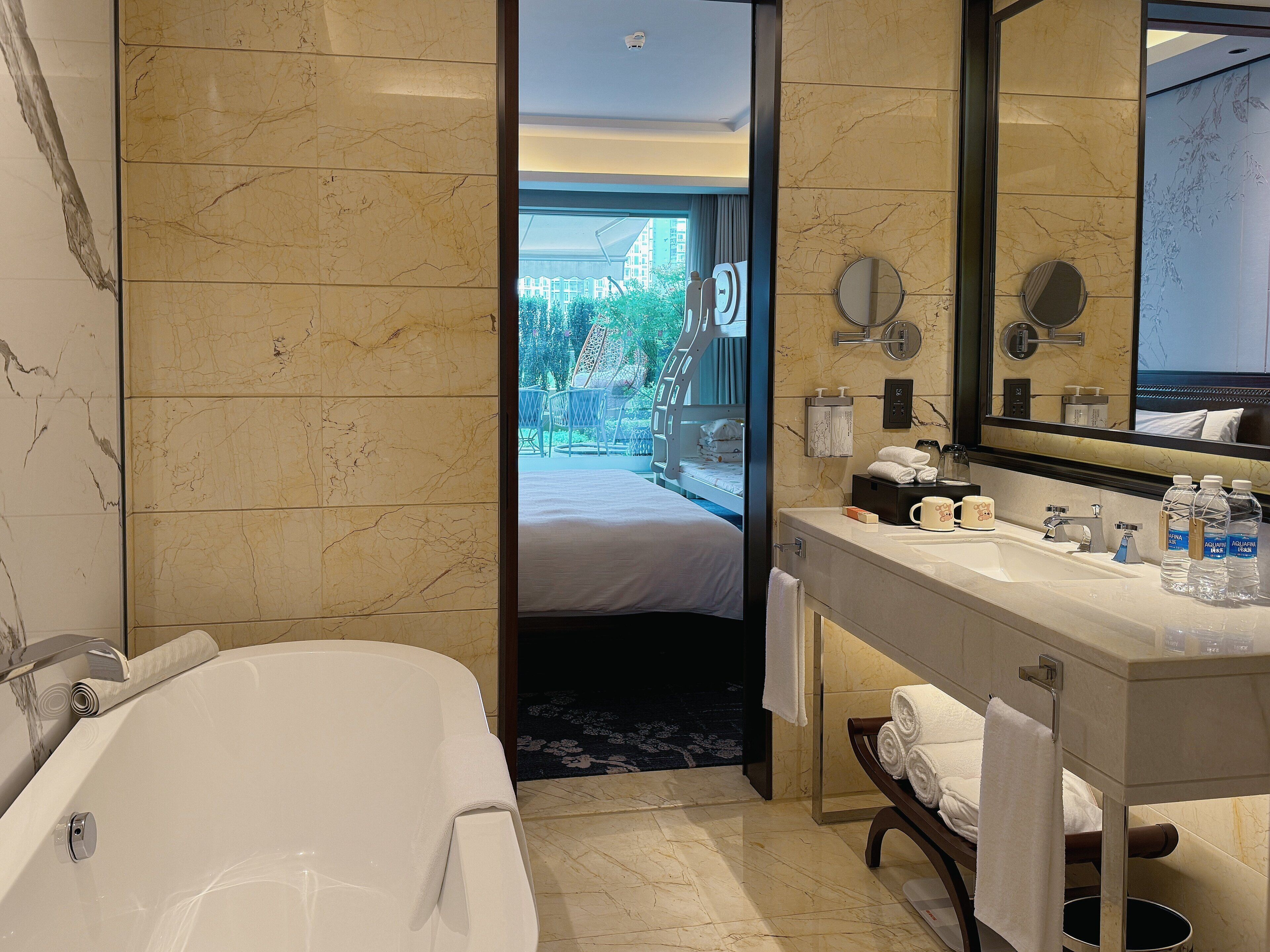 A modern bathroom with a bathtub, a vanity with toiletries, and a large mirror.
