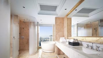 A modern bathroom with a large bathtub, a walk-in shower, and a vanity with a large mirror.