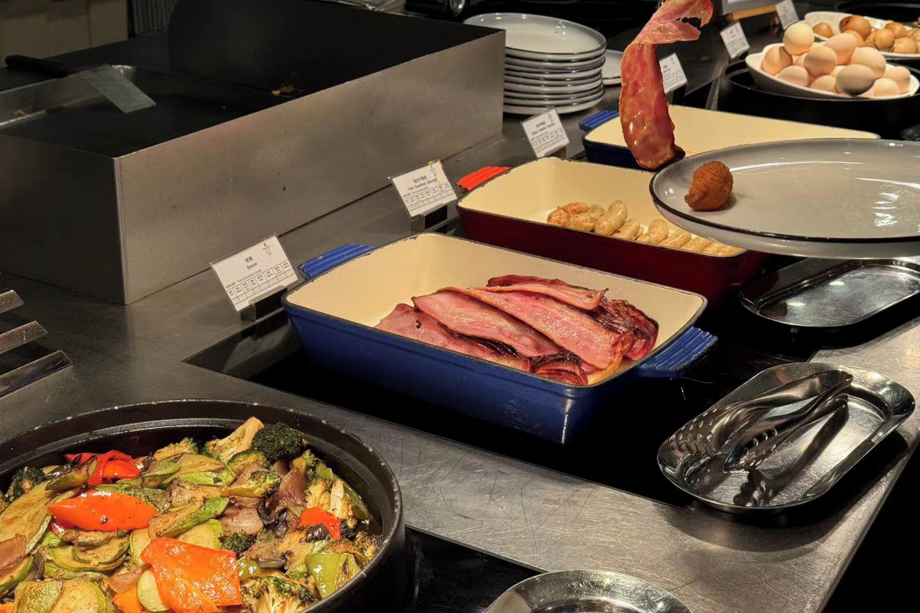 Un bufé con diversos alimentos, como carne, verduras y huevos.