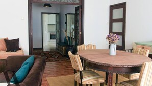 A dining area with a round wooden table, striped chairs, and a vase with dried flowers. - Beautiful 3-Bed Apartment in Porto, Portugal (Porto)