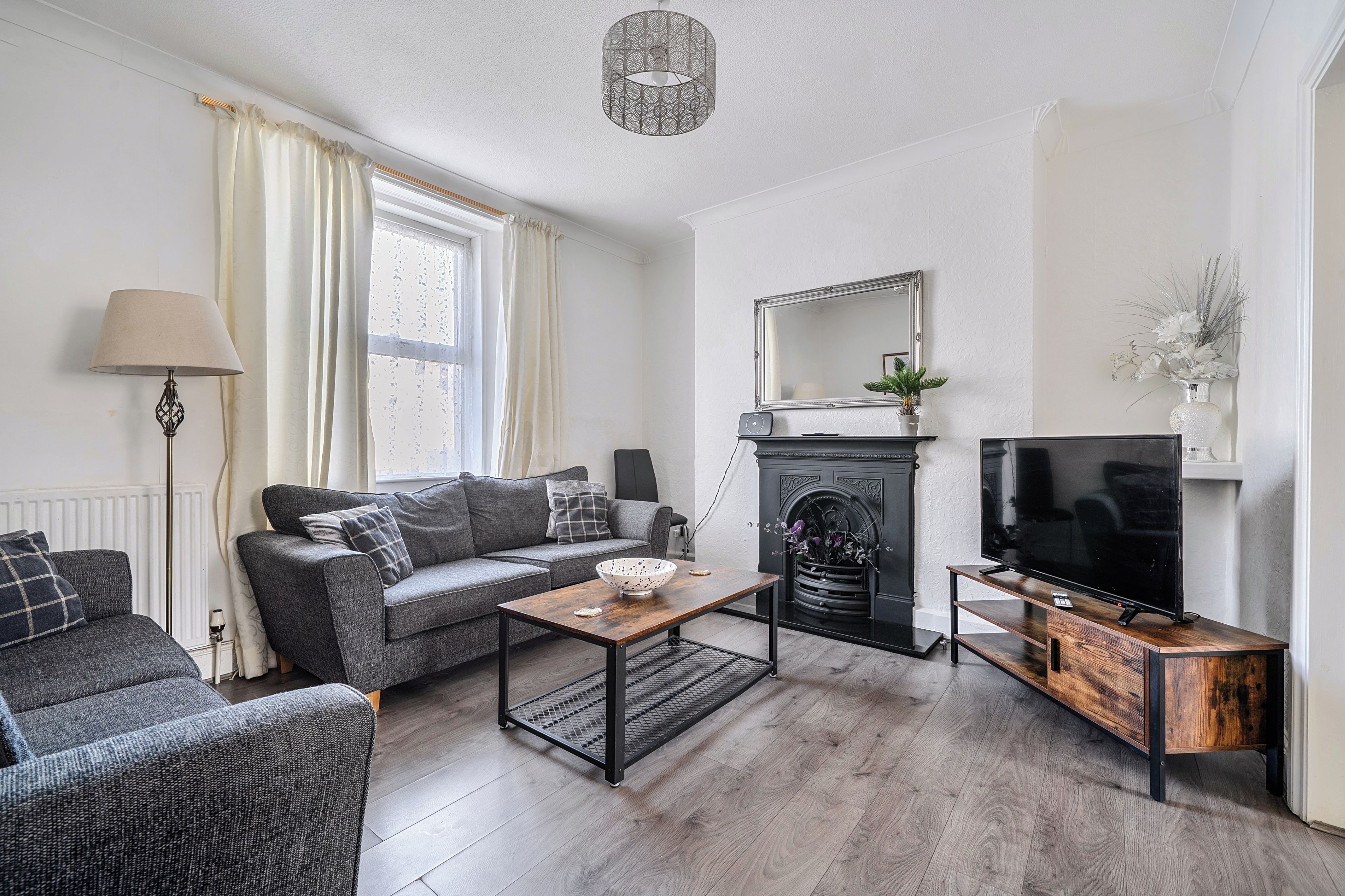 A living room with a sofa, a coffee table, a fireplace, and a television.