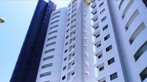 Um edifício alto com vários andares, com uma série de varandas e janelas.