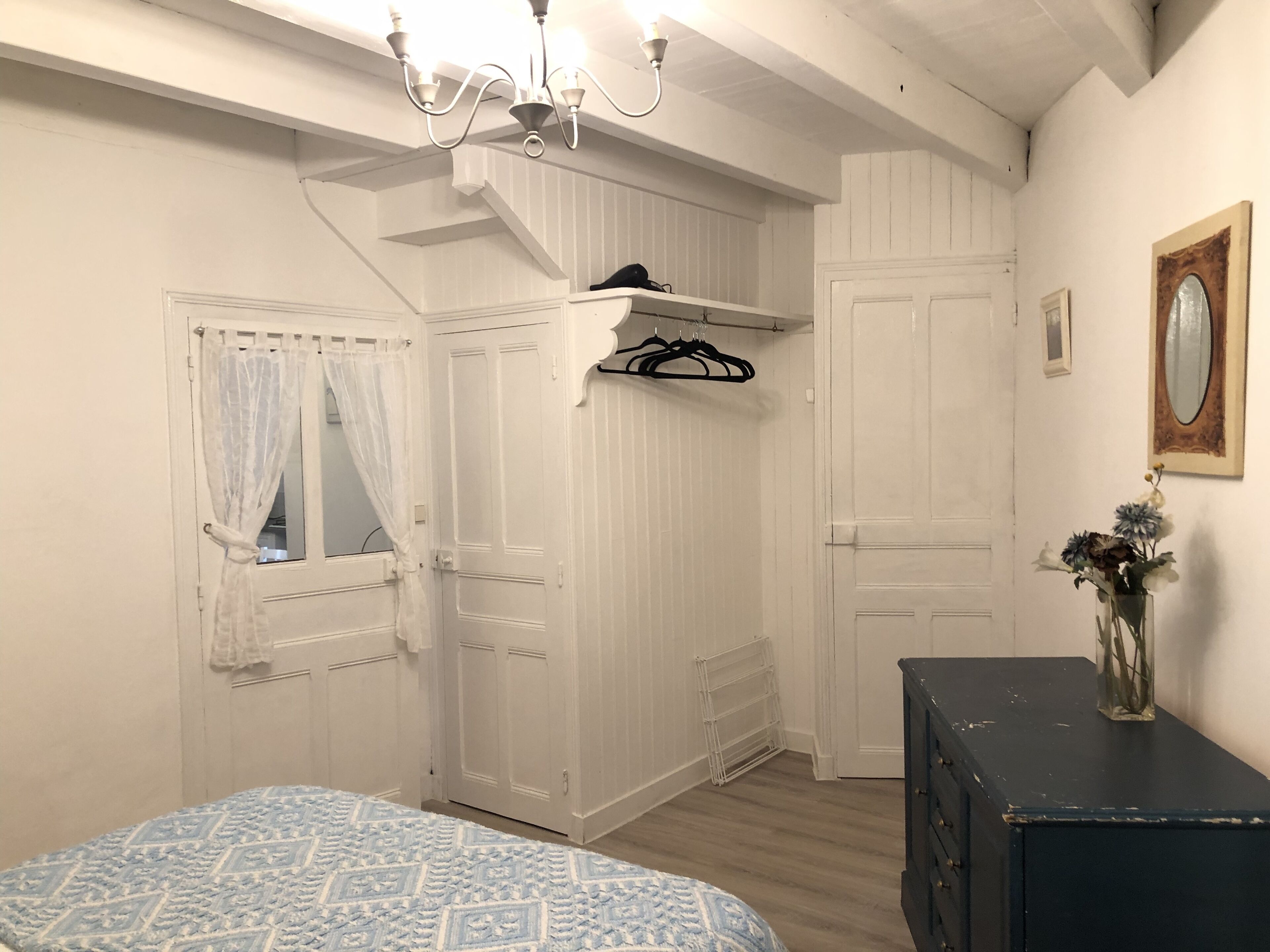 A bedroom with a bed, wardrobe, and dresser.