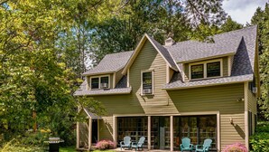 A two-story house with a covered patio area, a grill, and outdoor seating. - Ski season or yearly rental. Dogs loved! Walk to Equinox Pond & BBA. Fireplace (Manchester)
