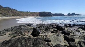 A rocky beach with waves, a sandy shore, and cliffs in the background. - Seaflower Cove: Spacious 4bd Oceanfront Retreat (Gualala)