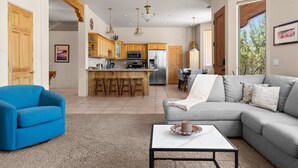 A modern kitchen with wooden cabinets, a central island with stools, stainless steel appliances, and pendant lighting. - Luxury Sedona Retreat • Hot Tub & Fire Pit (Sedona)