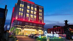 Un hôtel doté d’une façade moderne, de plusieurs étages et d’une enseigne lumineuse bien visible.