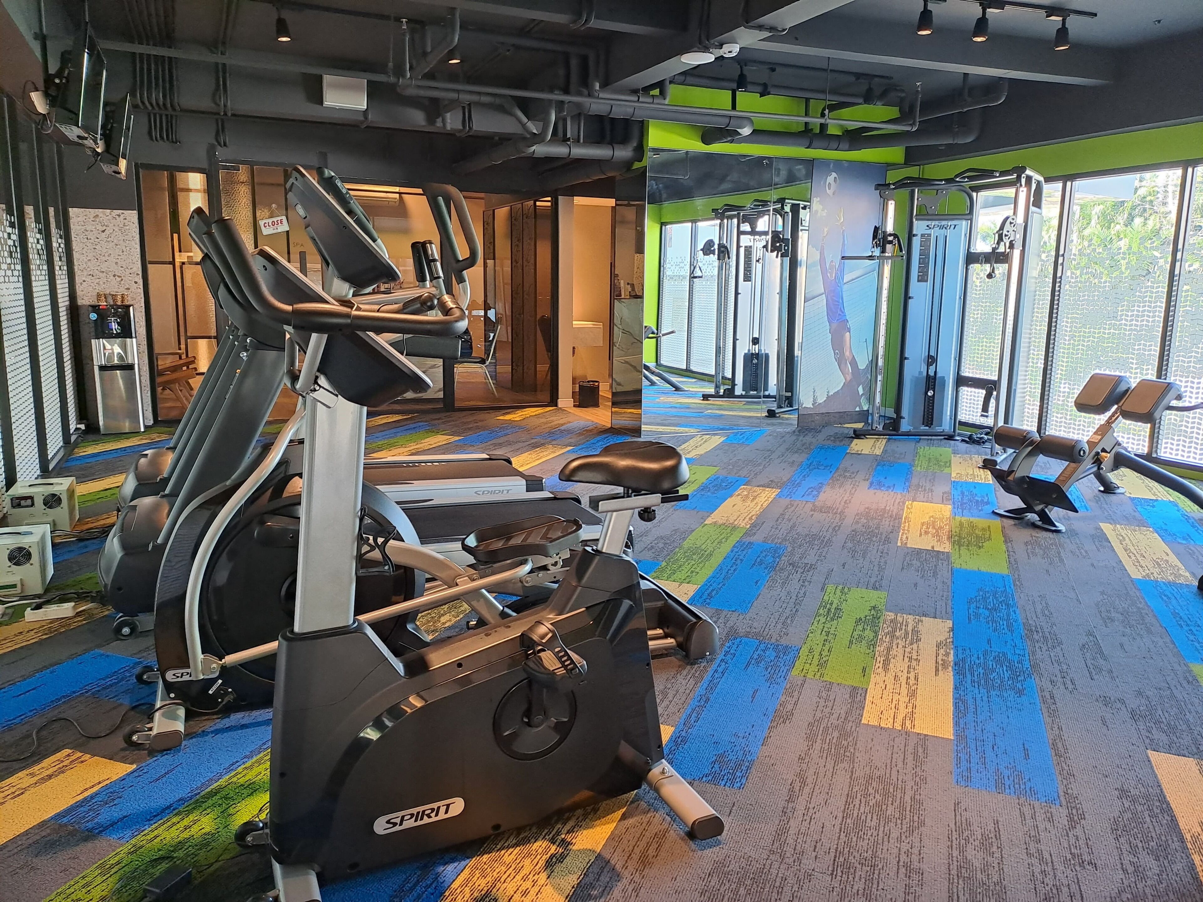 Une salle de sport équipée de tapis de course, de vélos elliptiques et de matériel de musculation.