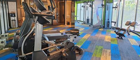 Ein Fitnessstudio mit Laufbändern, Crosstrainern und Gewichten.