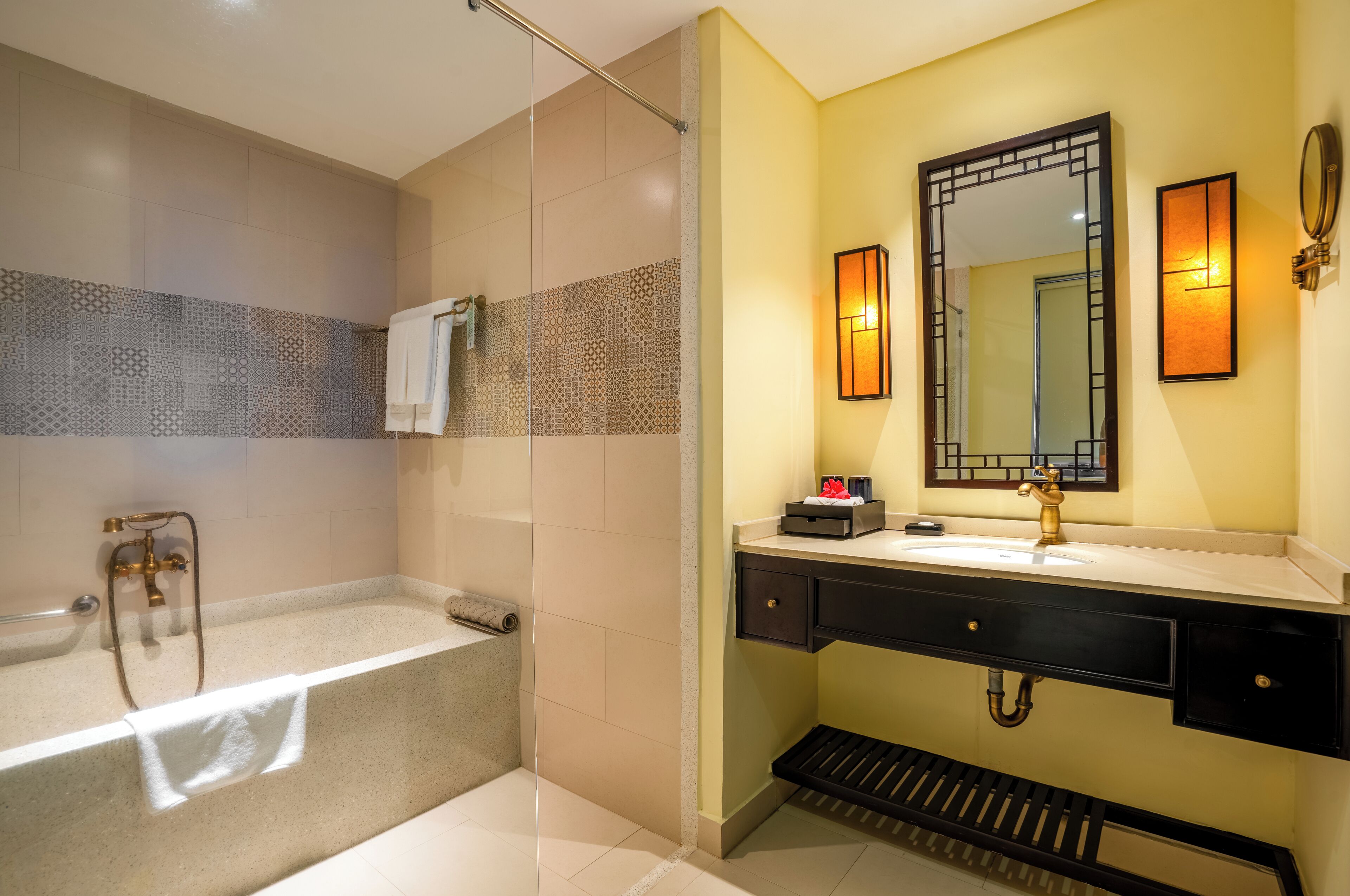 Een moderne badkamer met een bad, een douche, een wastafel met spiegel en een handdoekrek.