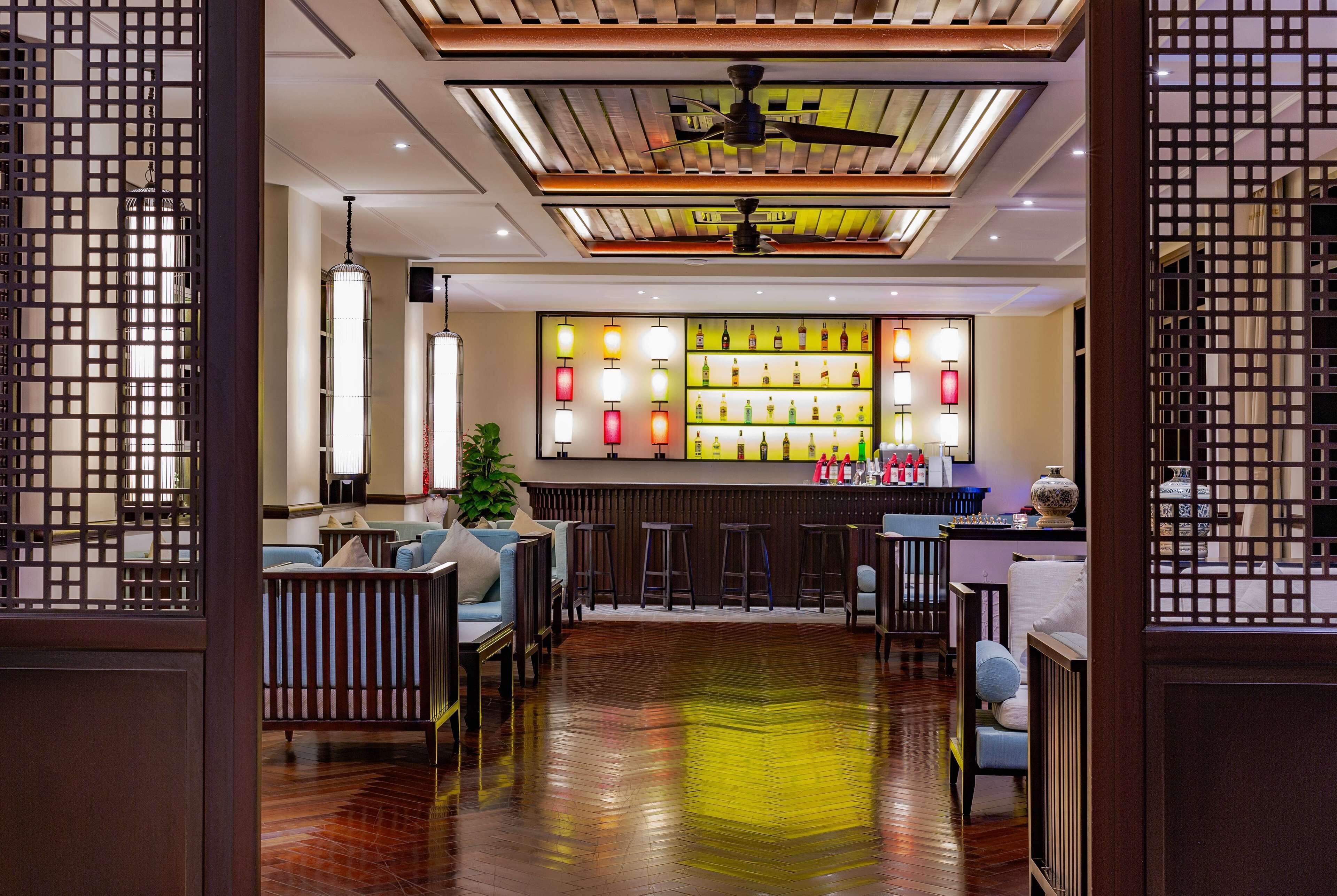 Zona de bar de estilo tradicional con muebles de madera y una exhibición de botellas.