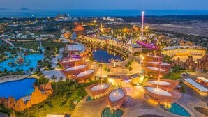 Vista aérea de un resort con varias piscinas, un parque acuático y una variedad de edificios del complejo.