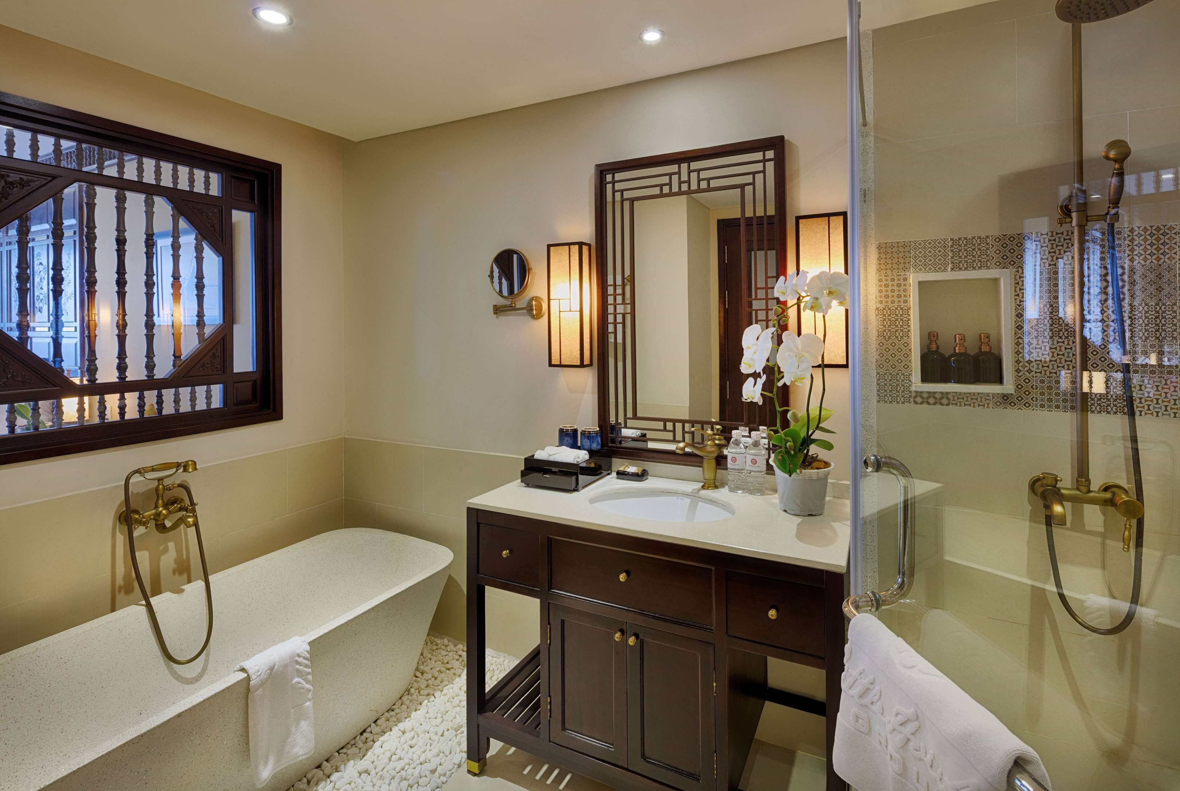 A modern bathroom with a freestanding bathtub, a vanity with a mirror, and a shower area.