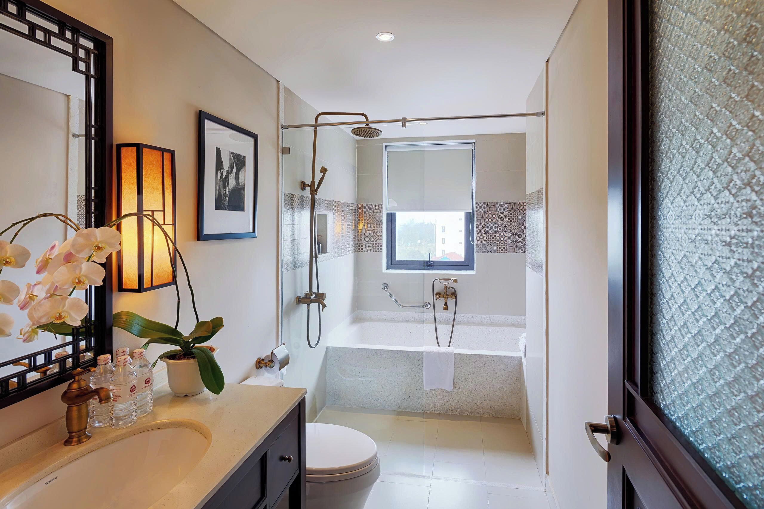 A modern bathroom with a bathtub, shower, toilet, and sink.