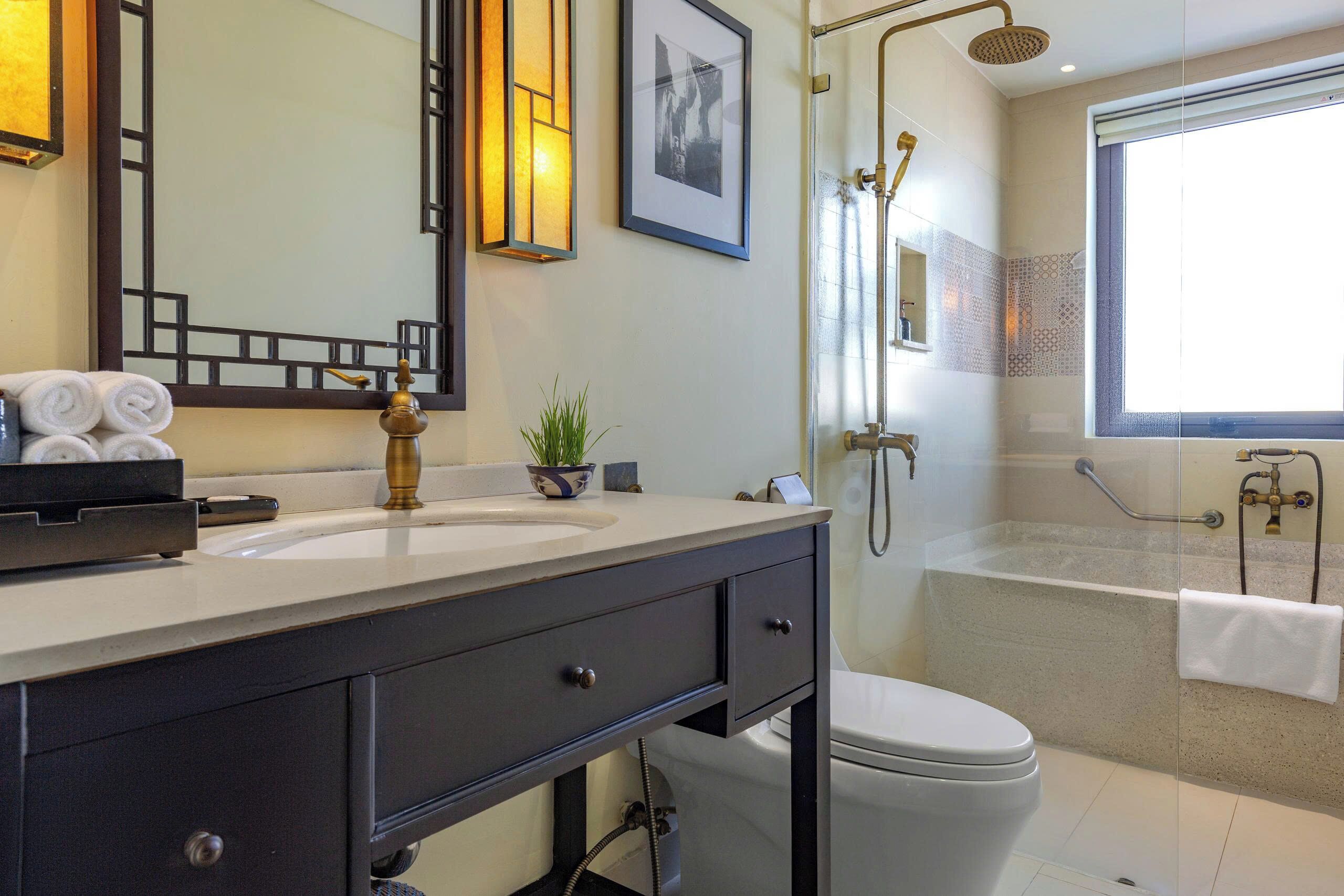 A modern bathroom with a sink, toilet, and shower area.