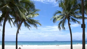 Una playa con palmeras y cielo despejado.