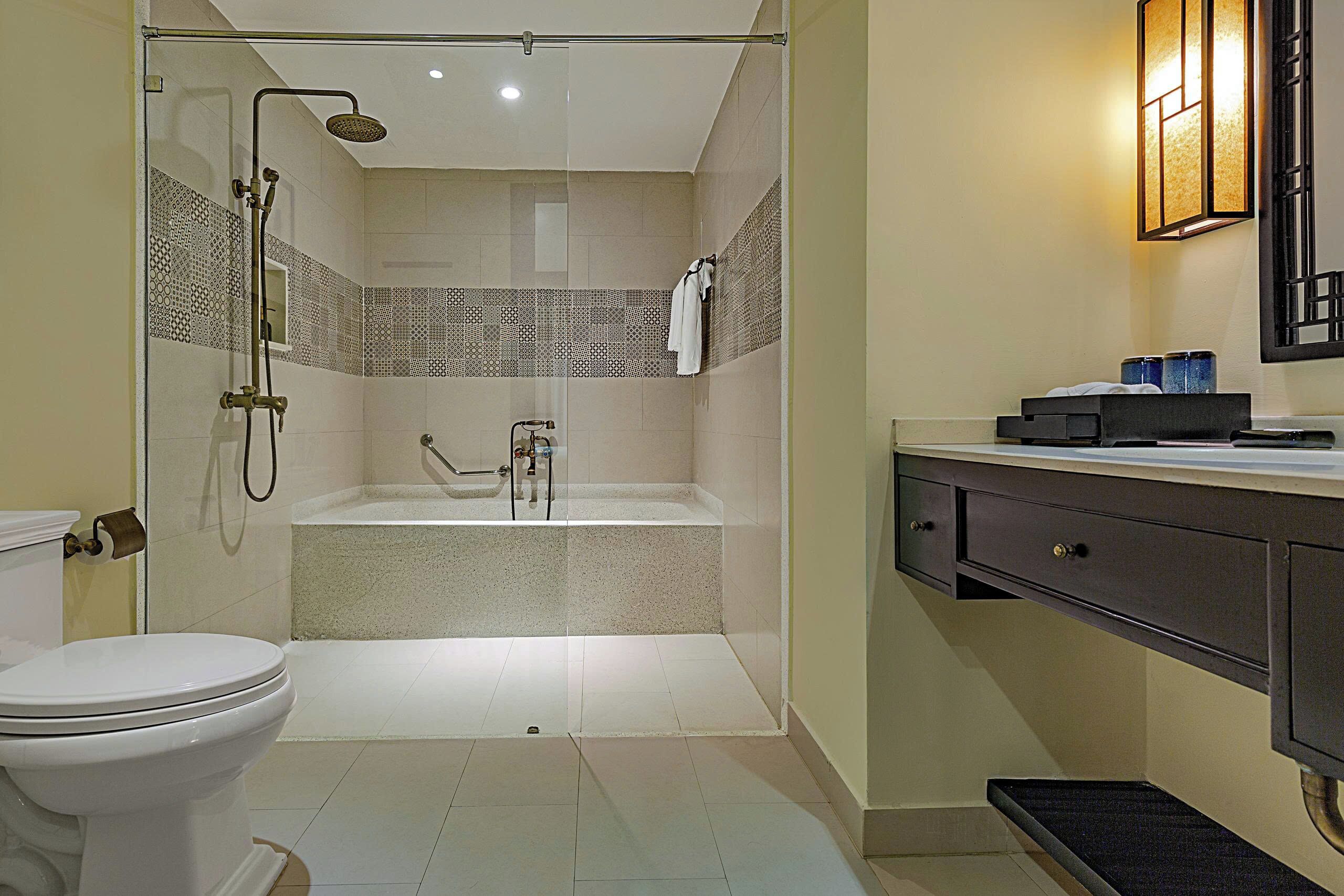A modern bathroom with a toilet, shower, and bathtub.