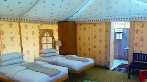 A room with two beds, a bench, and a door leading outside. - Raisar Camp (Bikaner)