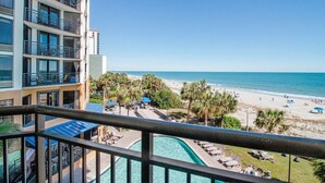 Un hôtel doté d'une piscine, offrant une vue sur la plage et comprenant plusieurs balcons.
