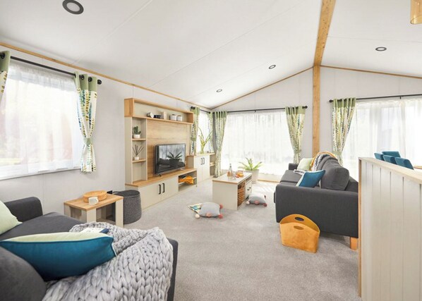Een moderne woonkamer met een televisie, bank en salontafel.