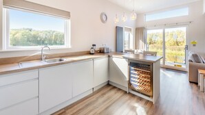 A modern kitchen with a large window, a built-in wine cooler, and a view of the outdoors.
