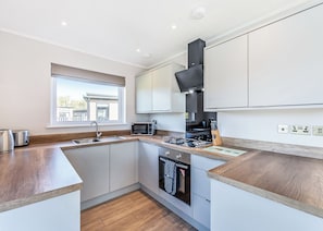 A modern kitchen with a window, built-in microwave, stove, and oven.