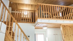 A wooden interior with a staircase leading to a loft area. - Kivakatti by Interhome (Sotkamo)
